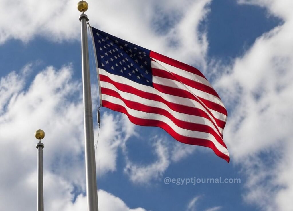 - Egypt Journal United States flag waving on a flagpole against a blue sky with white clouds.